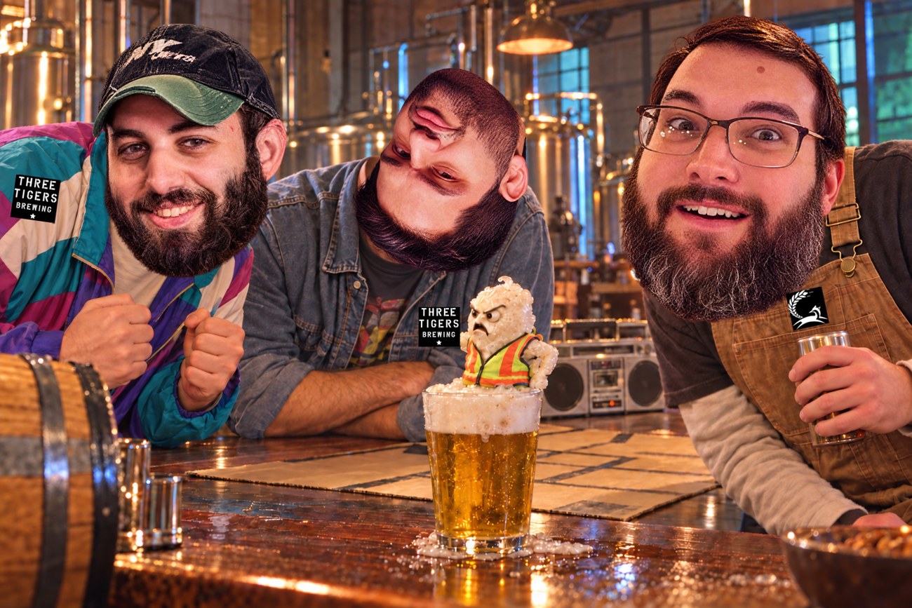 Frankie, upside-down-faced Logan, and Pinto leaning over a tiny vest-wearing yeast creature